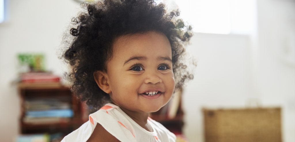 Happy Baby Girl Playing With Toys In Playroom