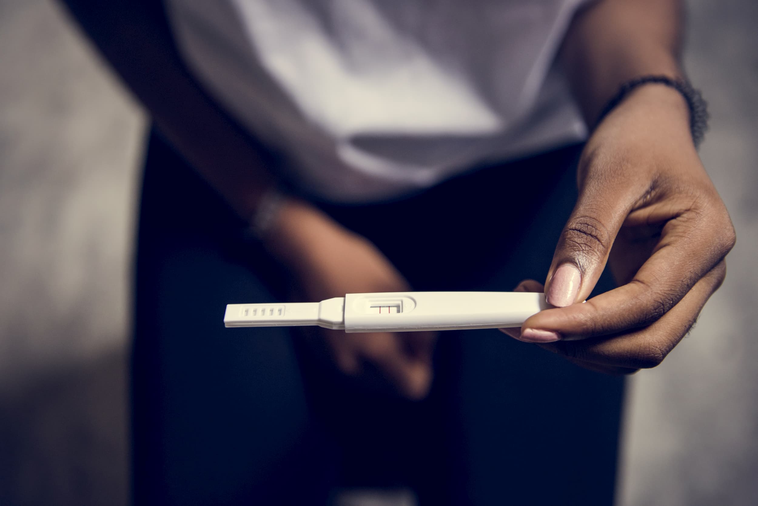 Female holding a pregnancy test which shows positive