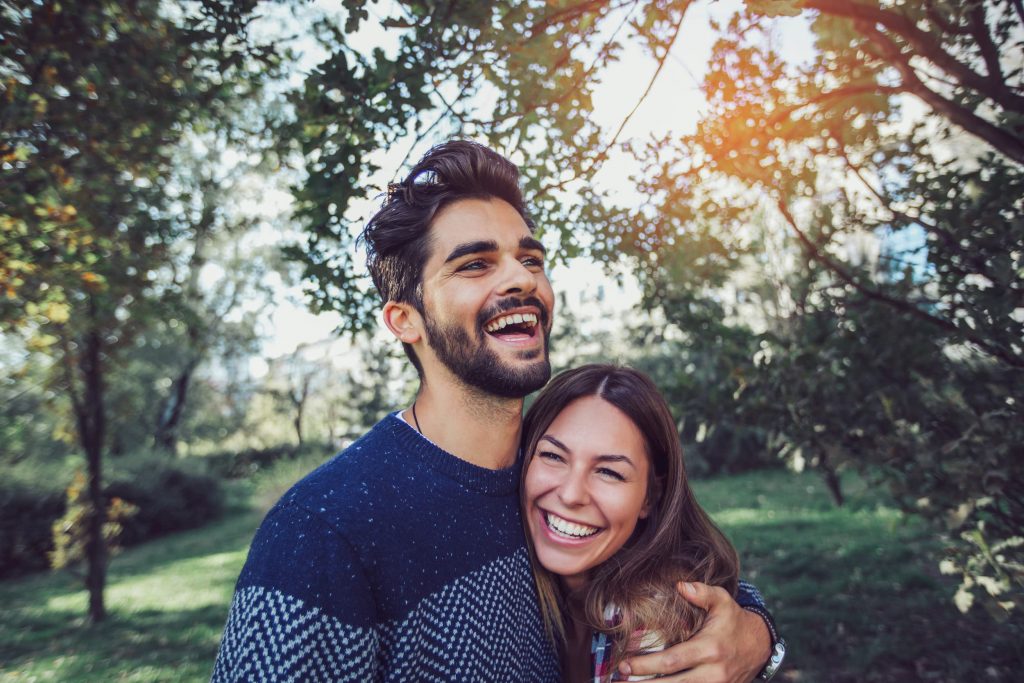 Smiling Man and woman in the park hugging