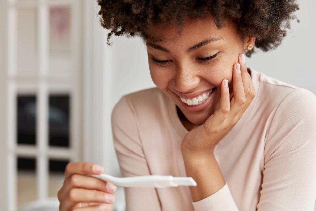 Smiling woman looking at her pregnancy test