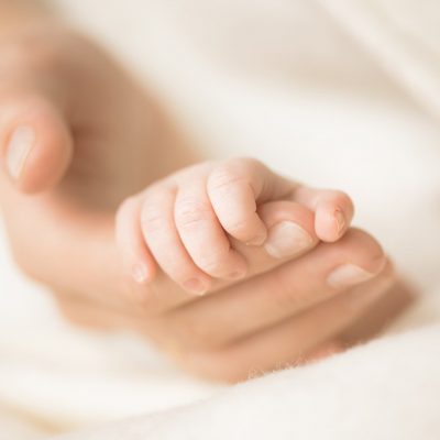 Baby holding an adults finger